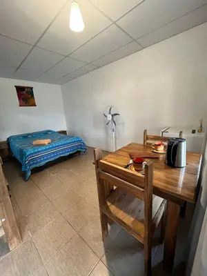 a room with a table and a bed at Cabañas La Chakana in Cortaderas
