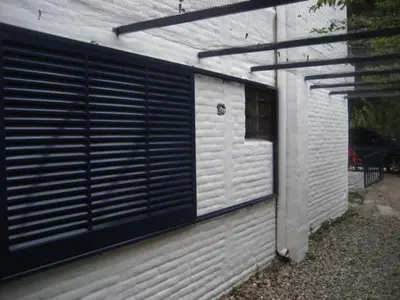 a white building with a window and a garage at casa 8 personas in Mina Clavero