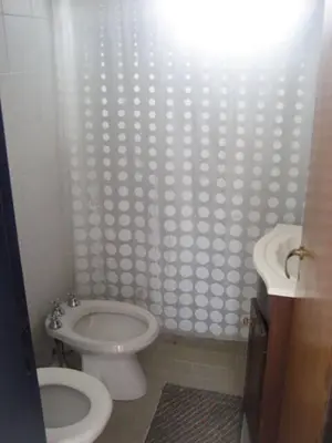 a bathroom with a white toilet and a sink at casa 8 personas in Mina Clavero