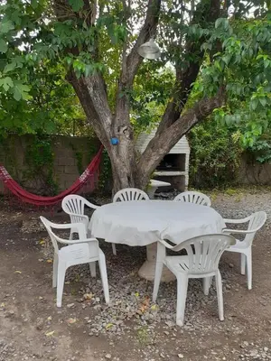 a white table and four chairs under a tree at casa 8 personas in Mina Clavero