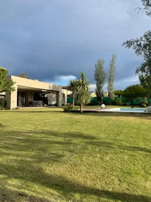 a house with a large lawn in front of it at CASA DE CATEGORIA EN LAS SIERRAS de CORDOBA in San Antonio de Arredondo