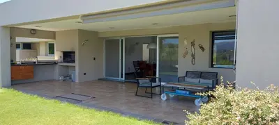 a house with a patio with a table and chairs at CASA DE CATEGORIA EN LAS SIERRAS de CORDOBA in San Antonio de Arredondo