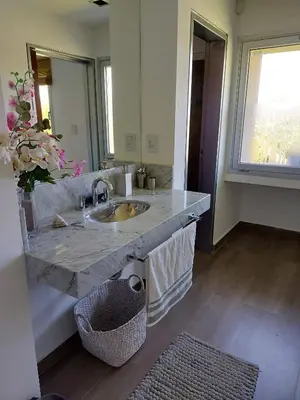 a bathroom with a marble sink and a mirror at CASA DE CATEGORIA EN LAS SIERRAS de CORDOBA in San Antonio de Arredondo