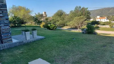 a grassy yard with trees and a building at CASA DE CATEGORIA EN LAS SIERRAS de CORDOBA in San Antonio de Arredondo