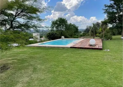 a swimming pool in a yard with a grass field at CASA DE CATEGORIA EN LAS SIERRAS de CORDOBA in San Antonio de Arredondo