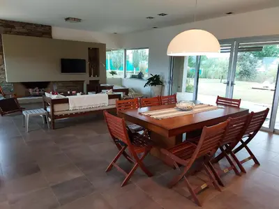 a dining room with a large wooden table and chairs at CASA DE CATEGORIA EN LAS SIERRAS de CORDOBA in San Antonio de Arredondo