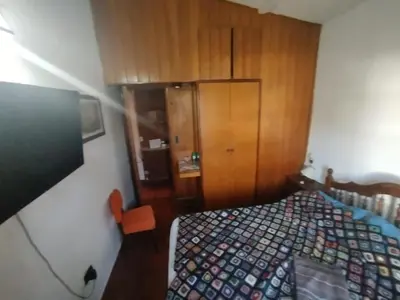 a bedroom with a bed and a wooden cabinet at Casa Costa Lago in Villa Carlos Paz