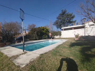 a shadow of a person standing next to a swimming pool at Casa Costa Lago in Villa Carlos Paz