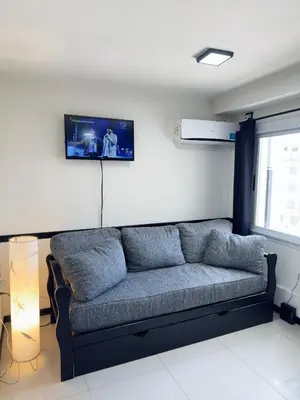 a couch in a living room with a tv on the wall at Guten Morgen VCP in Villa Carlos Paz