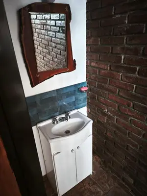 a bathroom with a sink and a brick wall at Departamento Villa Cabrera in Cordoba