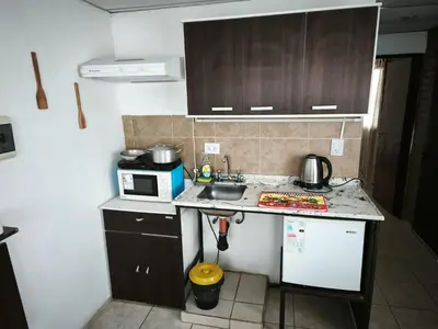 a small kitchen with a sink and a microwave at Departamento Villa Cabrera in Cordoba