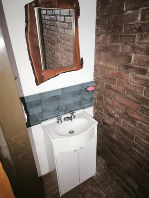 a bathroom with a sink and a brick wall at Departamento Villa Cabrera in Cordoba