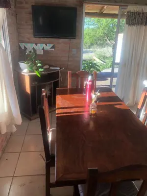 a dining room with a wooden table and a television at Casita El Mirador Trasla in Arroyo de Los Patos