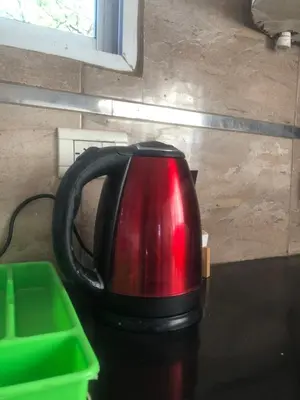 a red and black tea kettle sitting on a table at Casita El Mirador Trasla in Arroyo de Los Patos
