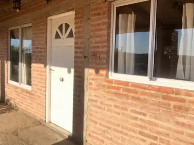 a brick house with a white door and windows at Casita El Mirador Trasla in Arroyo de Los Patos