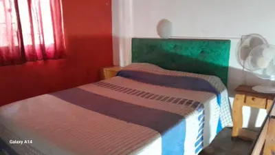 a bed in a room with red and green walls at Don Pinelli dptos in Alpa Corral