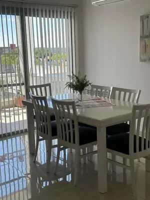 a white dining room table and chairs with a window at Casa de Mary in Villa Carlos Paz
