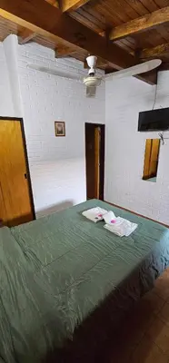 a bedroom with a green bed with towels on it at Hotel Francesco in Mina Clavero