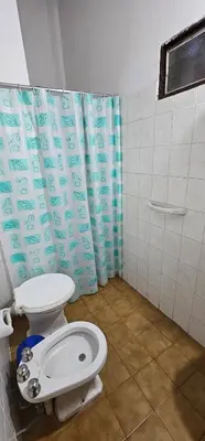 a bathroom with a toilet and a shower curtain at Hotel Francesco in Mina Clavero