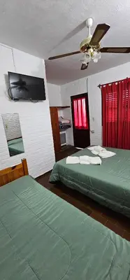 a bedroom with two green beds and a ceiling fan at Hotel Francesco in Mina Clavero
