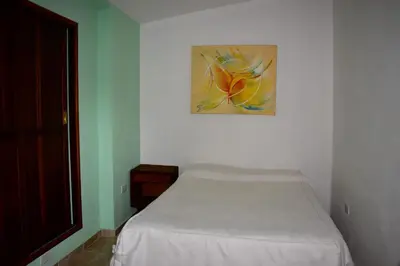 a bed in a room with a painting on the wall at Sierras Del Molle in Santa Rosa de Calamuchita