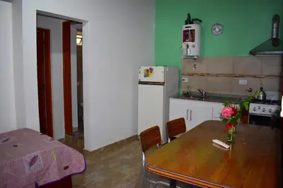 a kitchen with a wooden table and a dining room at Sierras Del Molle in Santa Rosa de Calamuchita