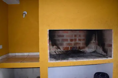 a brick fireplace in a yellow wall with a fire place at Sierras Del Molle in Santa Rosa de Calamuchita