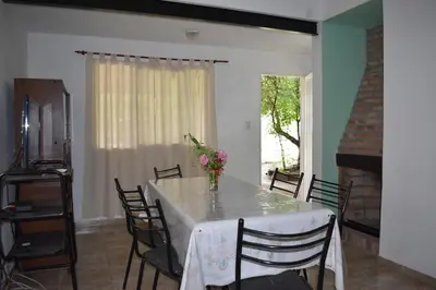a dining room with a table with chairs and a fireplace at Sierras Del Molle in Santa Rosa de Calamuchita