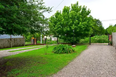 a garden with a fence and a tree at Sierras Del Molle in Santa Rosa de Calamuchita