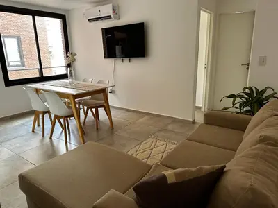 a living room with a couch and a table at NUEVO a 3 cuadras del shopping Patio Olmos con ASADOR y terraza amoblada in Cordoba