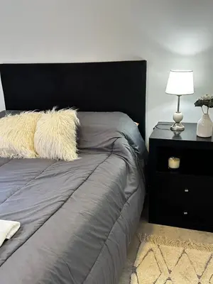 a bed with a black headboard and a lamp on a table at NUEVO a 3 cuadras del shopping Patio Olmos con ASADOR y terraza amoblada in Cordoba