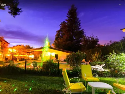 a yard with chairs and a building with a christmas tree at Bad-wiessee Apart Hotel & Spa in Villa General Belgrano
