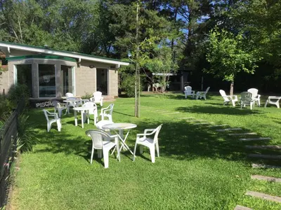 a group of tables and chairs in a yard at Bad-wiessee Apart Hotel & Spa in Villa General Belgrano