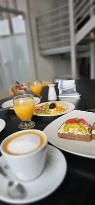 a table with plates of food and a cup of coffee at Alto Paz Tower Departamentos Premium in Cordoba