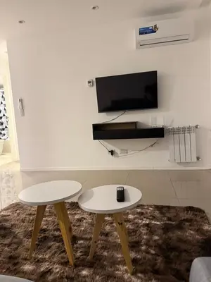 a living room with two tables and a tv at Alto Paz Tower Departamentos Premium in Cordoba