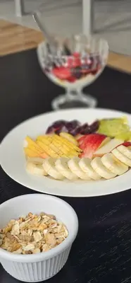 two plates of food with fruit and a bowl of nuts at Alto Paz Tower Departamentos Premium in Cordoba
