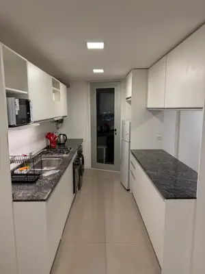 a kitchen with white cabinets and black counter tops at Alto Paz Tower Departamentos Premium in Cordoba