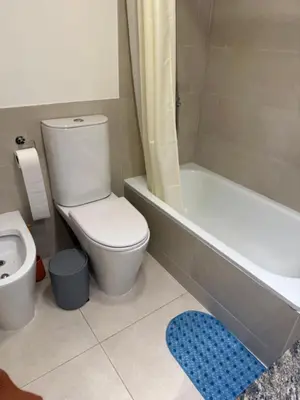 a bathroom with a toilet and a tub and a sink at Alto Paz Tower Departamentos Premium in Cordoba
