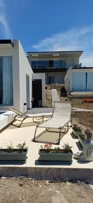 a building with two chairs and flowers in front of it at Anima Lodge 2 in Villa Carlos Paz