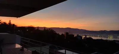 a view of a sunset from a balcony at Anima Lodge 2 in Villa Carlos Paz