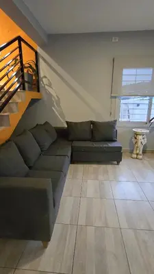 a living room with a couch and a staircase at Las Nalichas in Villa Carlos Paz