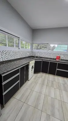 a kitchen with black cabinets and a washer and dryer at Las Nalichas in Villa Carlos Paz
