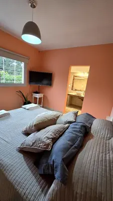 a large bed with pillows on it in a bedroom at Las Nalichas in Villa Carlos Paz