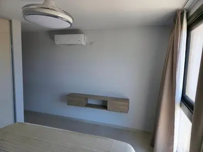 a room with a bed and a shelf on the wall at Apartamento Ópera Park in Cordoba