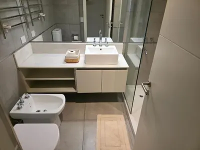 a bathroom with a sink and a toilet and a mirror at Apartamento Ópera Park in Cordoba