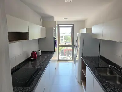 a kitchen with white cabinets and black counter tops at Apartamento Ópera Park in Cordoba