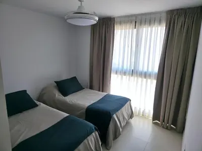 two beds in a room with a window at Apartamento Ópera Park in Cordoba