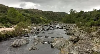 a river with rocks and trees and a mountain at Mountain house in Costa Blanca in Cuesta Blanca