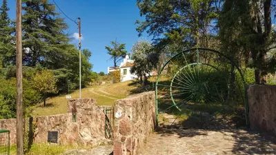 a gate to a field with a house on a hill at Mountain house in Costa Blanca in Cuesta Blanca