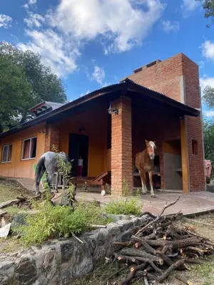 two horses standing outside of a brick house at El Paraíso de las Chacras in Las Chacras (La Paz)